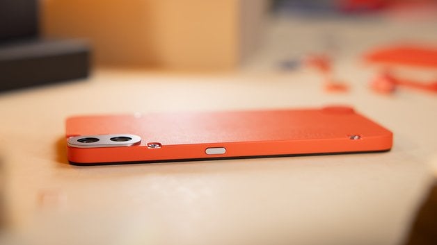 Le CMF Phone 1 vu de côté et posé à plat sur une table.