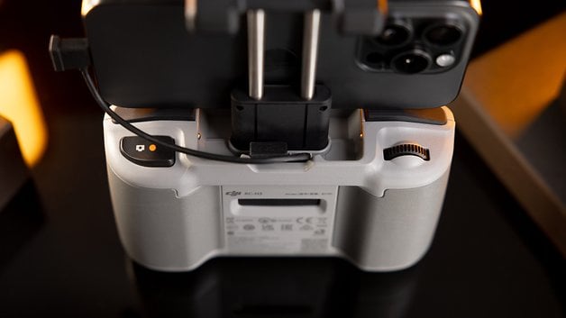 Close-up of a DJI RC controller with mounted smartphone showing buttons and ports.