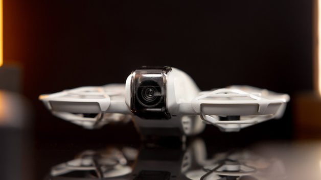 Front view of the DJI Neo drone, showing off its camera and sleek design against a dark background.