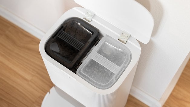 A trash can ​designed with two compartments - one ‌dark and one clear.