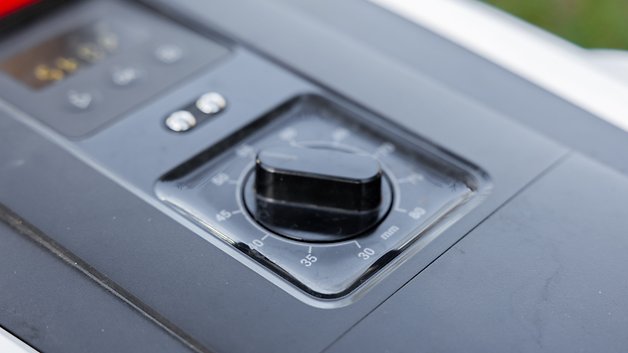 Gros plan d'un panneau de contrôle avec un bouton circulaire pour régler les paramètres.
