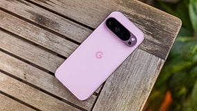 A Google Pixel 9 Pro smartphone in pink color resting on a wooden table.