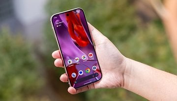 Une personne tenant un smartphone Google Pixel 9 Pro affichant un écran d'accueil coloré.