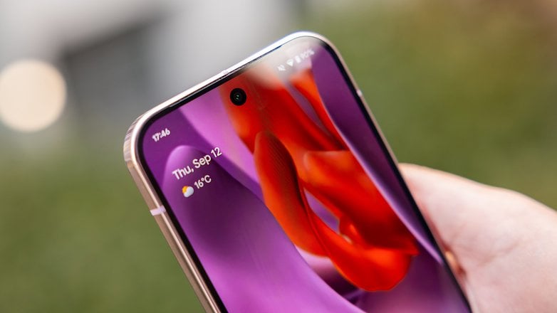 Close-up of a hand holding a Google Pixel 9 Pro smartphone displaying the date and weather.