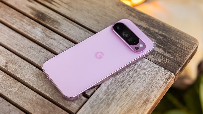 Un smartphone Google Pixel 9 Pro en rosa, reposando sobre una mesa de madera.