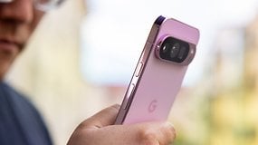 Um close-up de um smartphone Google Pixel 9 Pro na mão de uma pessoa, apresentando um design rosa e câmeras duplas.