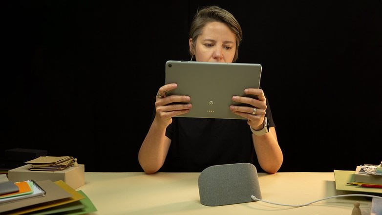 Camila hält am Tisch das Google Pixel Tablet in Händen