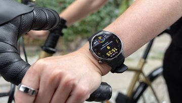 A close-up of a Huawei Watch GT 6 Pro on a person's wrist while holding a bicycle handlebar.