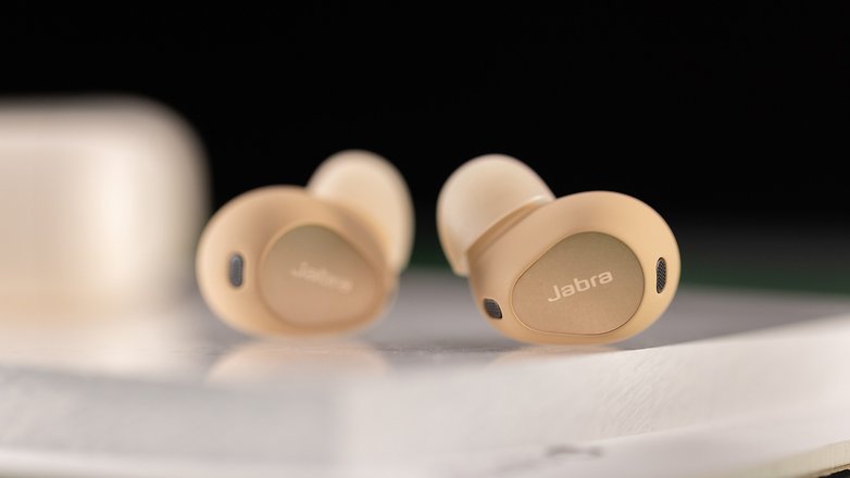 Les Jabra Elite 10 vus de face et posés l'un en face de l'autre sur une table