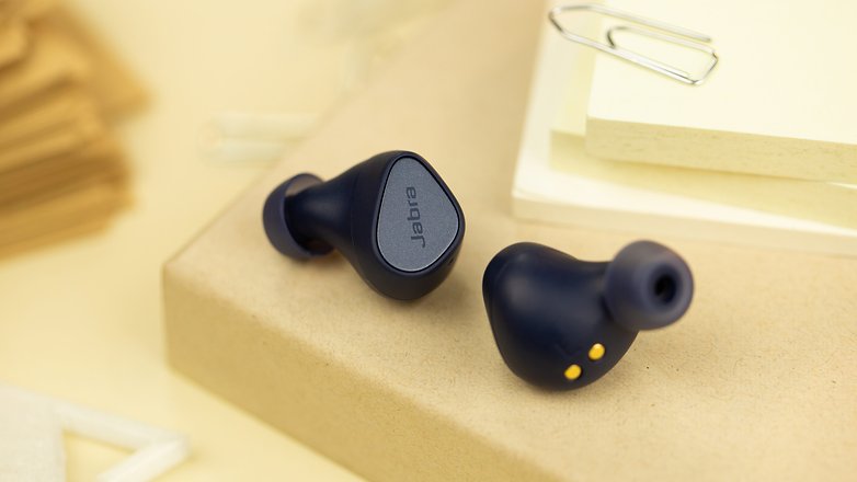 Les Jabra Elite 4 posés à plat et vus de face avec un aperçu des boutons physiques de chaque écouteur