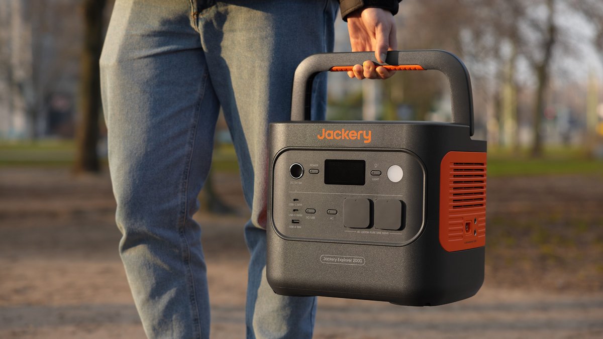 Une personne tient une station d'énergie portable Jackery Explorer 2000 à l'extérieur.