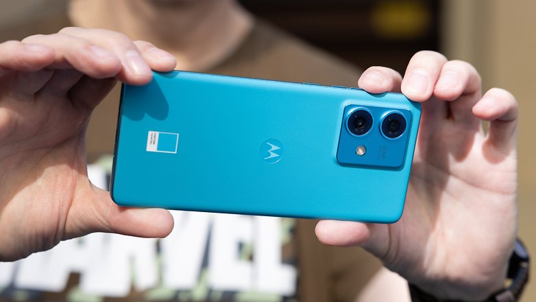 Le Motorola Edge 40 Neo tenu horizontalement à deux mains et vu de dos Le Motorola Edge 40 Neo tenu horizontalement à deux mains et vu de dos