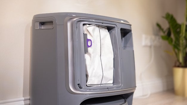 A grey device with a removable white filter in an open compartment.