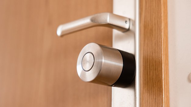 Gros plan d'un Nuki Smart Lock Pro monté sur une porte en bois.