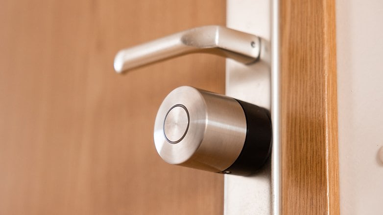 Nahaufnahme eines Nuki Smart Lock Pro, das an einer Holztür montiert ist.