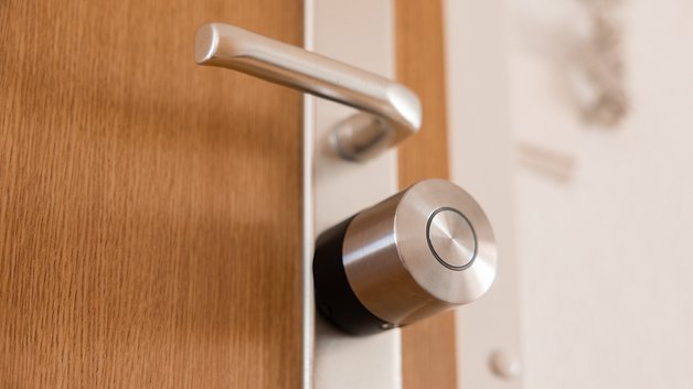 Nahaufnahme eines Nuki Smart Lock Pro, das an einer Holztür angebracht ist.