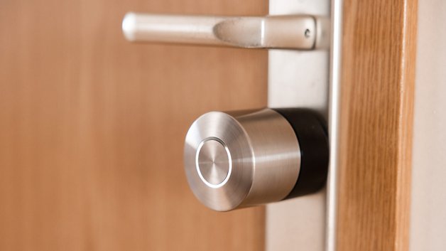 Nahaufnahme eines Nuki Smart Lock Pro, installiert an einer Holztür.