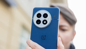 A person holding the blue back of a OnePlus 13 smartphone, showcasing its camera design.