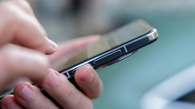 A person holding a OnePlus 13 smartphone, focusing on the screen.