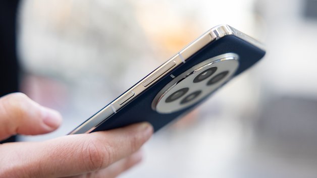 A person holding the OnePlus 13 smartphone, showcasing its sleek design and camera module.