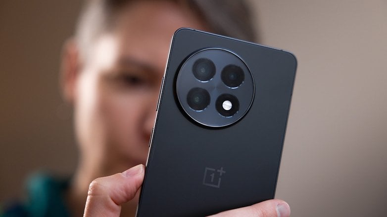 Eine Nahaufnahme eines OnePlus 13R-Smartphones, das von einer Person gehalten wird, zeigt das Kameradesign.