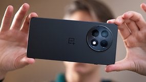 Uma pessoa segurando a parte de trás de um smartphone OnePlus 13R, exibindo seu design de câmera.