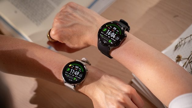 Two wrists wearing OnePlus Watch 3 with vibrant displays showing fitness statistics.