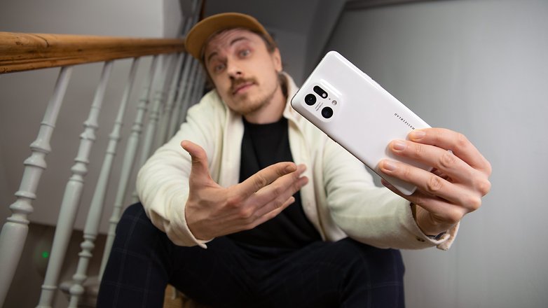 Ben sitzt auf einer Treppe und hält das Oppo Find X5 Pro in der Hand