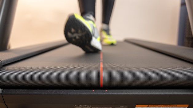 A person walking on a Peloton Tread—belt highlighted