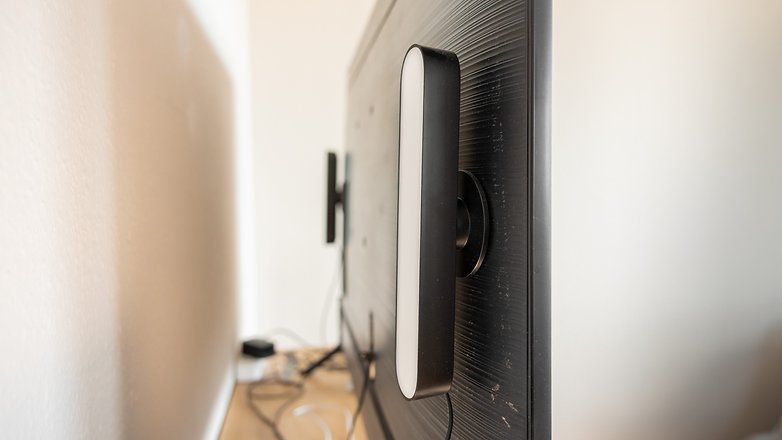 Un dispositif d'éclairage intelligent Philips Hue fixé à l'arrière d'un moniteur. Un dispositif d'éclairage intelligent Philips Hue fixé à l'arrière d'un moniteur.