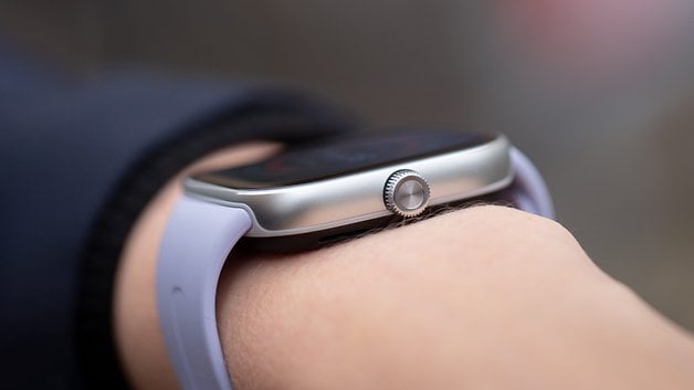 Gros plan d'une Redmi Watch 5 sur un poignet, avec un boîtier argenté et un bracelet violet clair.