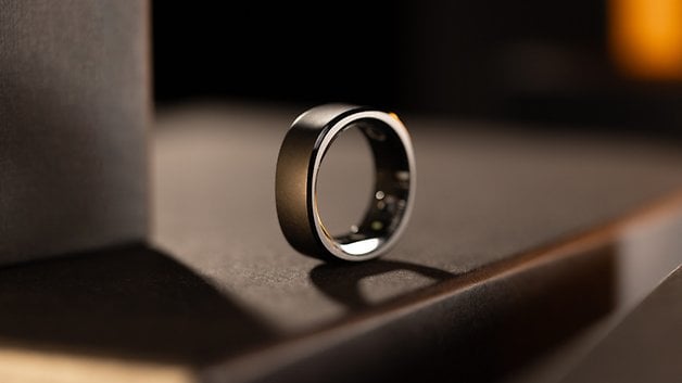 Close-up of a sleek black smart ring on a dark surface, showcasing its modern design.