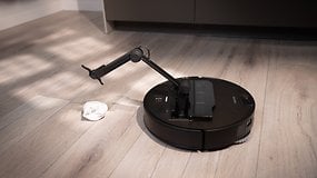 Ein Roborock Saros Z70 Saugroboter auf einem Holzboden neben einem Tuch.