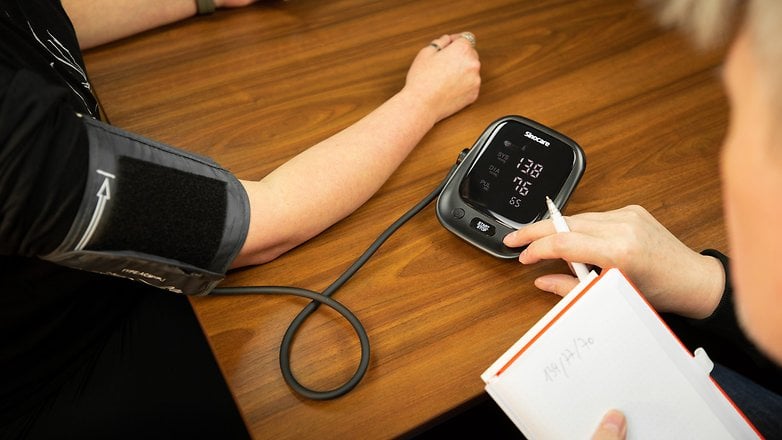 A person monitoring the blood pressure of another person