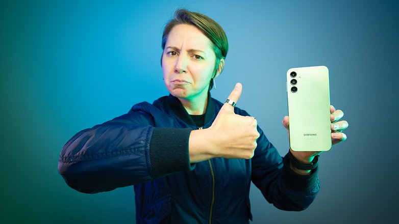 Seorang editor yang memegang Samsung Galaxy A14 meniru meme Brent Rambo