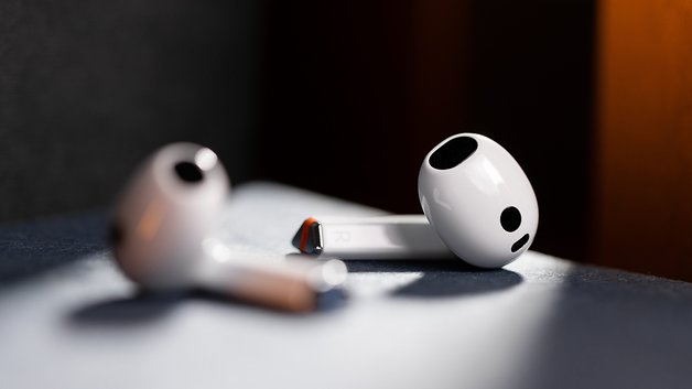 Two Samsung Galaxy Buds 3 with a white finish resting on a surface.