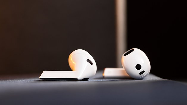 Two Samsung Galaxy Buds 3 lying on a dark surface, showing off their sleek white design.