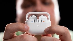 A person holding a white earbuds case with earbuds inside, focusing on the Samsung Galaxy Buds 3.