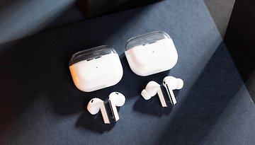 Zwei Paare Samsung Galaxy Buds 3 kabelloser Ohrhörer mit ihren Ladecases auf einer dunklen Oberfläche.