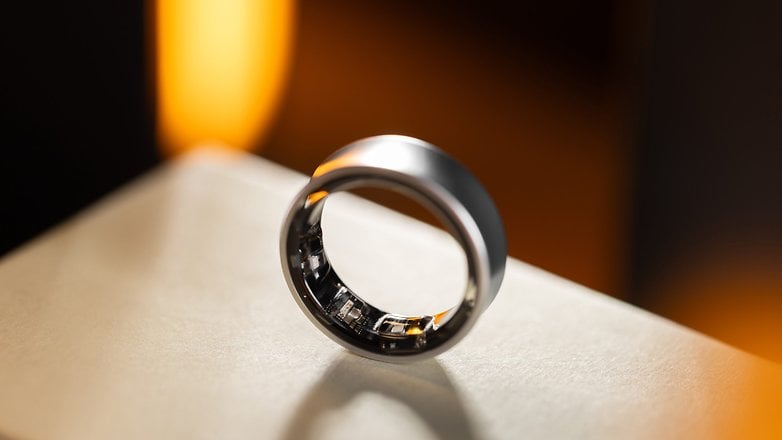 Ein eleganter Samsung Galaxy Ring, der auf einer Oberfläche mit sanftem Lichthintergrund präsentiert wird.