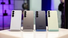 Vier Samsung Galaxy S25 Smartphones in verschiedenen Farben auf einem Ständer präsentiert.