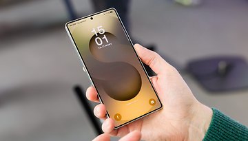 Eine Person hält ein Samsung Galaxy S25-Smartphone, das die Uhrzeit 15:01 auf dem Sperrbildschirm anzeigt.