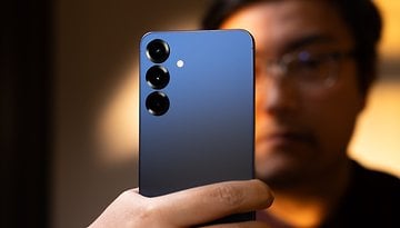 Une personne tenant un smartphone Samsung Galaxy S25 Plus avec un dos dégradé bleu et trois lentilles de caméra.