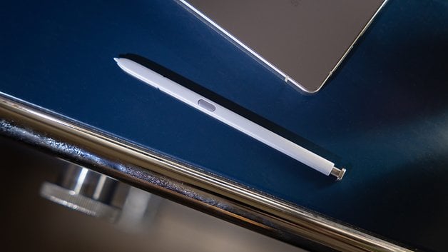 Un stylet blanc posé sur une surface brillante à côté d'un appareil.