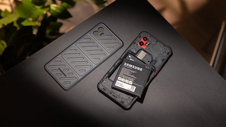 Samsung Galaxy XCover 7 Pro with removable battery and protective case on a dark surface. Samsung Galaxy XCover 7 Pro with removable battery and protective case on a dark surface.