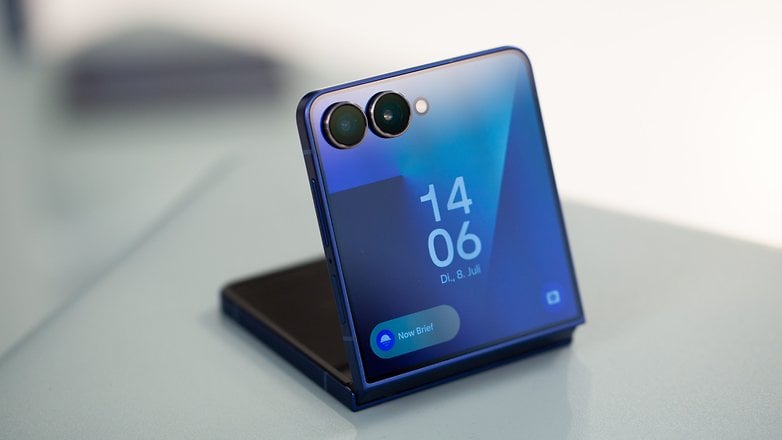 A Samsung Galaxy Z FLIP7 okostelefon olyan szögben jelenik meg, amelynek kék formatervezése és óra a képernyőn. A Samsung Galaxy Z FLIP7 okostelefon olyan szögben jelenik meg, amelynek kék formatervezése és óra a képernyőn.