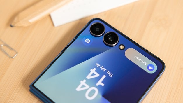 Nahaufnahme eines Samsung Galaxy Z Flip7 Smartphones mit zwei Kameras und einem teilweise sichtbaren Bildschirm.