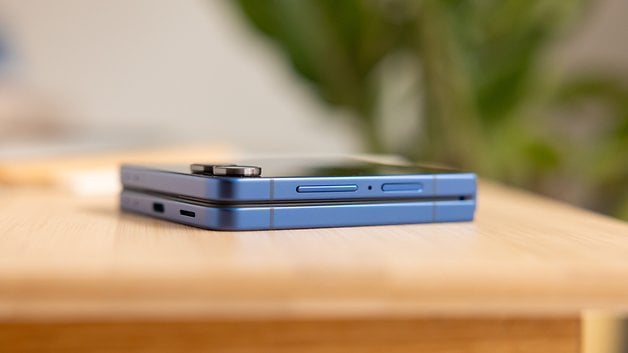 Ein gefaltetes Samsung Galaxy Z Flip 7 Smartphone auf einer Holzoberfläche.