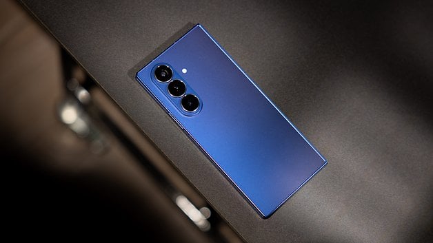 A blue Samsung Galaxy Z Fold7 smartphone lying on a dark surface.