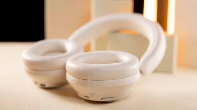 Casque audio blanc sur une surface claire avec un fond doux.